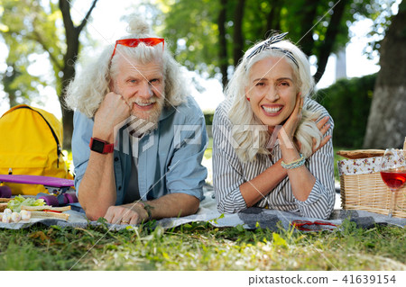 Pleasant joyful couple lying on the grass Pleasant joyful couple lying on the grass 41639154
