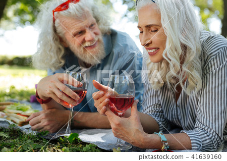 Cheerful positive woman looking at the glass with wine Cheerful positive woman looking at the glass with wine 41639160