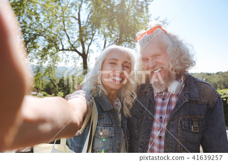 Cheerful aged woman holding a camera Cheerful aged woman holding a camera 41639257