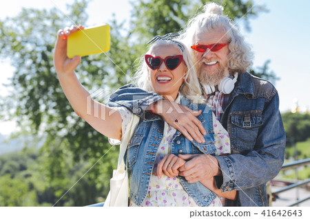 Nice cheerful woman holding her smartphone Nice cheerful woman holding her smartphone 41642643