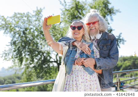 Joyful aged woman taking selfies with a smartphone Joyful aged woman taking selfies with a smartphone 41642648