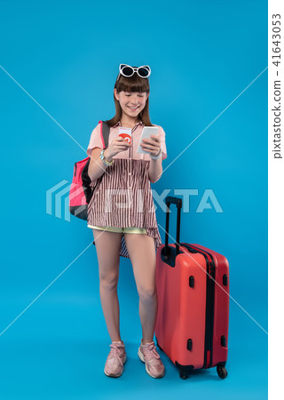 Exuberant girl standing with her phone Exuberant girl standing with her phone 41643053