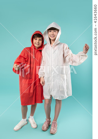 Smiling kids wearing lovely raincoats 41643660