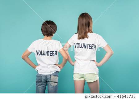 Young volunteers holding their hands on their waists Young volunteers holding their hands on their waists 41643735