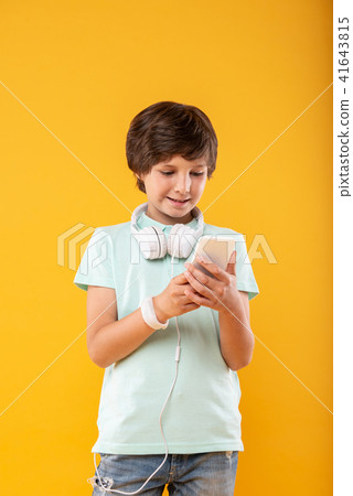 Delighted boy using his modern phone Delighted boy using his modern phone 41643815