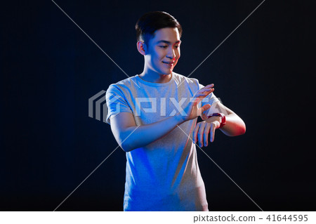Positive cheerful man using a smartwatch 41644595
