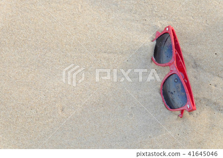 A red sun glasses at the beach, on the sand. A red sun glasses at the beach, on the sand. 41645046