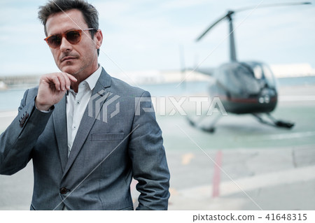 Businessman near private helicopter 41648315