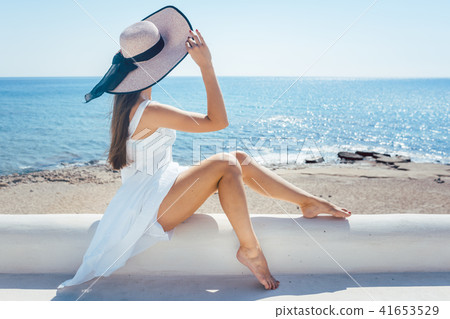 Woman sitting in the sun on a greek beach 41653529