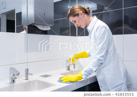 Janitor cleaning sink in public washroom Janitor cleaning sink in public washroom 41653553