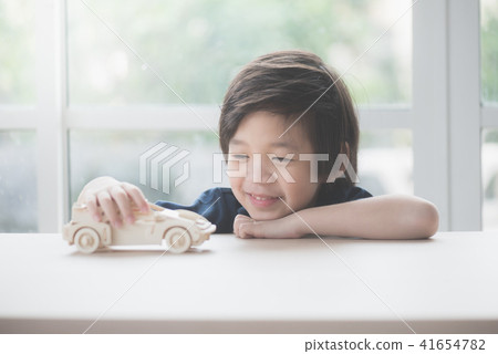 Asian child playing wooden model car Asian child playing wooden model car 41654782
