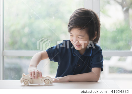 Asian child playing wooden model car Asian child playing wooden model car 41654885