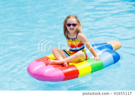 Child on inflatable float in swimming pool. Child on inflatable float in swimming pool. 41655117