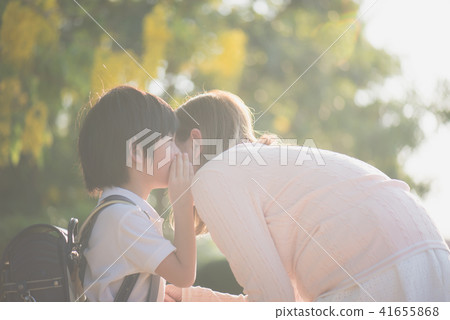 boy whispers something to his mother boy whispers something to his mother 41655868