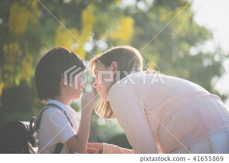boy whispers something to his mother boy whispers something to his mother 41655869