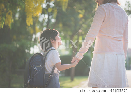 Mother holding hand of little son with backpack Mother holding hand of little son with backpack 41655871
