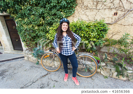 Young woman with a bicycle posing on the alley 41656366