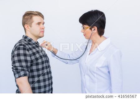 healthcare, medical exam, people and medicine concept - young man and doctor with stethoscope healthcare, medical exam, people and medicine concept - young man and doctor with stethoscope 41656567