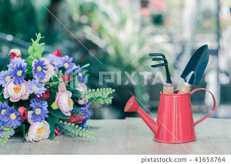 red watering can and garden tool on wood red watering can and garden tool on wood 41658764