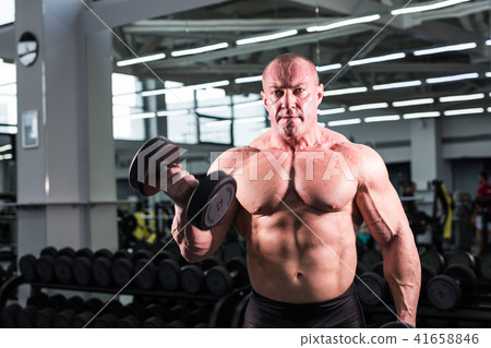 Bodybuilder man with perfect biceps, triceps and chest in the gym 41658846