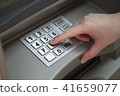 Close-up of hand entering PIN pass code on ATM bank machine keypad 41659077