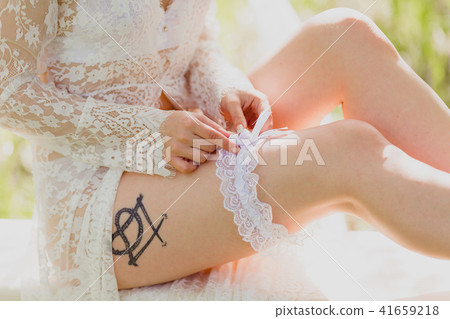Seductive young bride dressing white garter 41659218