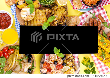 Different fruits and vegetables on grilled and shrimp. Yellow background. Summer dinner. Free space 41659644