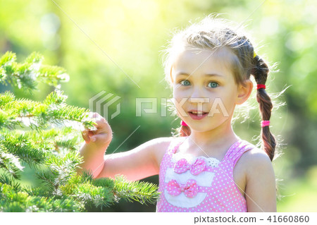 A 5 year old girl in a pink dress in the forest. 41660860