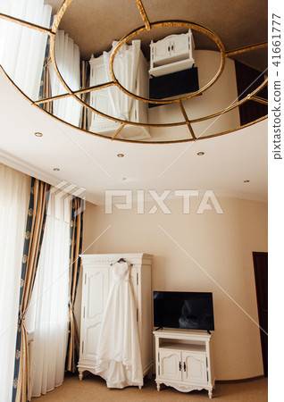 Wedding dress hanging on the cupboard Wedding dress hanging on the cupboard 41661777