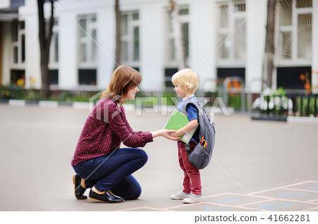 Back to school concept. Little pupil with his young mother. First day of primary school. Back to school concept. Little pupil with his young mother. First day of primary school. 41662281