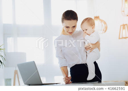 Attentive businesswoman working with her child 41662591
