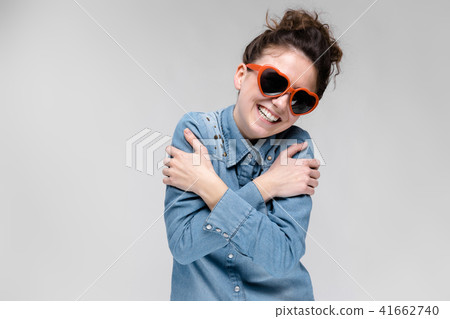 Young brunette girl with glasses in the form of a heart. The hairs are gathered in a bun. The girl 41662740