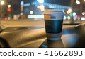a cup of coffee is on the dashboard of the car 41662893