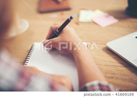 Young hipster woman writing and work in workplace. Young hipster woman writing and work in workplace. 41669189