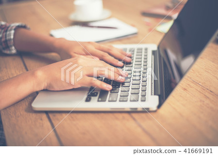Close-up woman hands typing on laptop in office. Close-up woman hands typing on laptop in office. 41669191