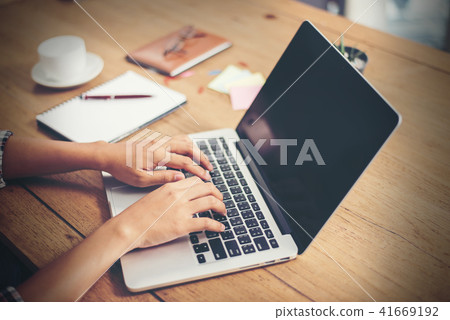 Close-up woman hands typing on laptop in office. Close-up woman hands typing on laptop in office. 41669192