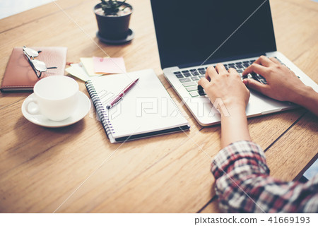 Close-up woman hands typing on laptop in office. 41669193