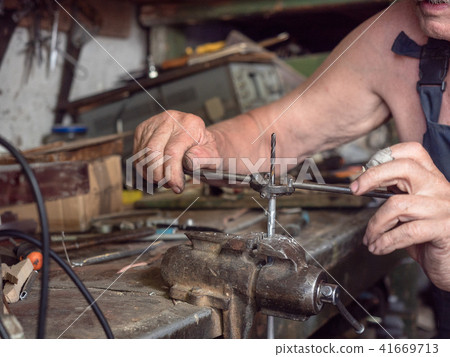 Older man in harnees at home workshop. Close up 41669713