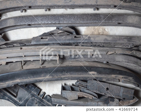 An old broken vehicle car bumpers piled together 41669714