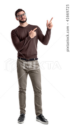 A bearded man in smart casual clothes looks in front to camera and points sideways with both hands A bearded man in smart casual clothes looks in front to camera and points sideways with both hands 41669725