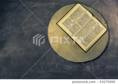Open Holy Bible on a stone round table. Open Holy Bible on a stone round table. 41670806