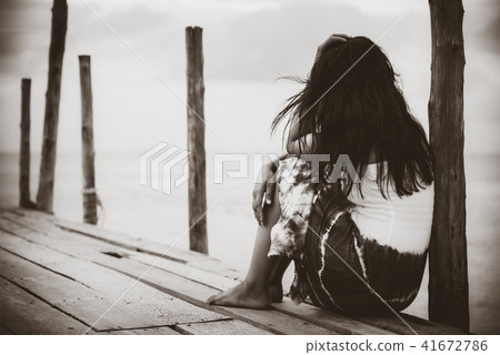 Sad and lonely woman sitting alone 41672786