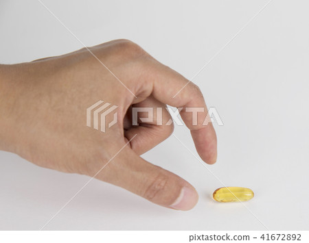 A person holding a pill in his hand 41672892