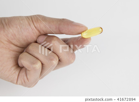 A person holding a pill in his hand 41672894