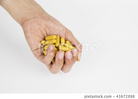 A person holding a pill in his hand 41672898