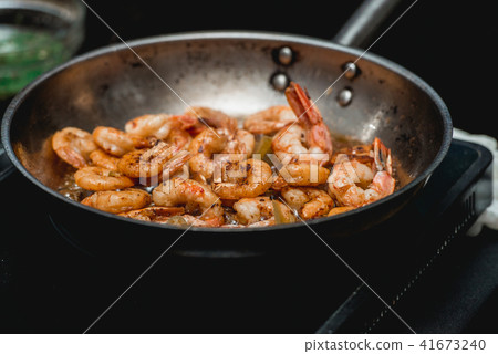 Shrimp on frying pan. Thermal processing of food. Electric cooker in a restaurant Shrimp on frying pan. Thermal processing of food. Electric cooker in a restaurant 41673240