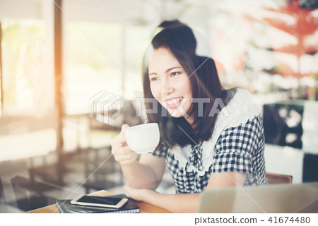 Beautiful woman sitting and drinking coffee  41674480