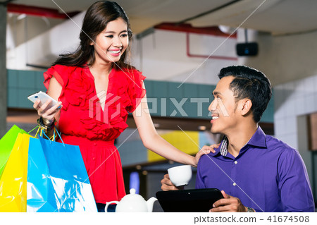 Beautiful young woman holding three shopping paper bags 41674508