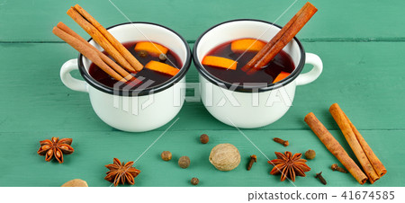 Hot red mulled wine on wooden background Hot red mulled wine on wooden background 41674585