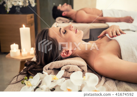 Man relaxing with his partner on massage beds at wellness center Man relaxing with his partner on massage beds at wellness center 41674592